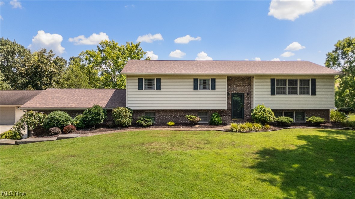 This beautifully maintained split foyer home offers over 2,300 sq. ft. of living space and a layout perfect for both comfort and entertaining. The main level features a large living room, kitchen and dining room, and three generous bedrooms, including a master ensuite, plus a second full bath. Enjoy bright and airy living spaces and the spacious kitchen with hardwood floors, ample cabinetry, and all appliances included. The adjoining dining room opens to a back deck with gorgeous views of fields and woods. The lower level boasts a huge family room/recreation area with wood-burning stove and new carpeting, laundry room, and an additional flex space ideal for an office or hobby room. An attached 2-car garage adds convenience, while the detached 32x30 two-level garage is a dream for hobbyists or professionals—structurally reinforced for heavy machinery, hoists, and more. There is also a large building with electric behind the detached garage perfect for storage. Set up from the road with a pretty gravel driveway, this property offers privacy, beauty, and exceptional upkeep. Recent updates include a new roof, new heat pump and furnace and new water heater. This is a truly move-in-ready home with incredible views and versatile space. Located in Warren Local School District! Set up your showing today!