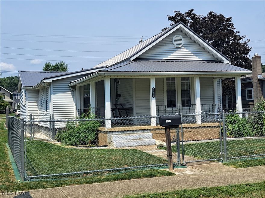 ADORABLE, CLEAN BUNGALOW offers a fenced-in front yard and covered L-shaped front porch overlooking scenic Park Place. The front door invites you into a brightly lit living room with hall archway and wood laminated flooring. This move-in ready home also has a nice, eat-in kitchen with plenty of countertops, walnut cabinets and lazy Susan with a large room located just across the wide hallway that could serve as a master bedroom, family room or formal dining room with its built-in hutch/TV cabinet. Two more bedrooms, a full bath with large vanity, and laundry with washer, dryer, shelving and cabinets off the kitchen complete the first floor. The partial, unfinished, clean basement with newer hot water tank is a great place for storage with a B-Dry system and sump pump already installed.  The exterior of the home has vinyl siding and a newer metal roof (2019) with a 7x7 Craftsman shed, a shaded pet or sitting area and plenty of rear parking. Tour this wonderful home to see its park-like setting that's also located just a block away from recreation/ball fields that your family will truly enjoy.