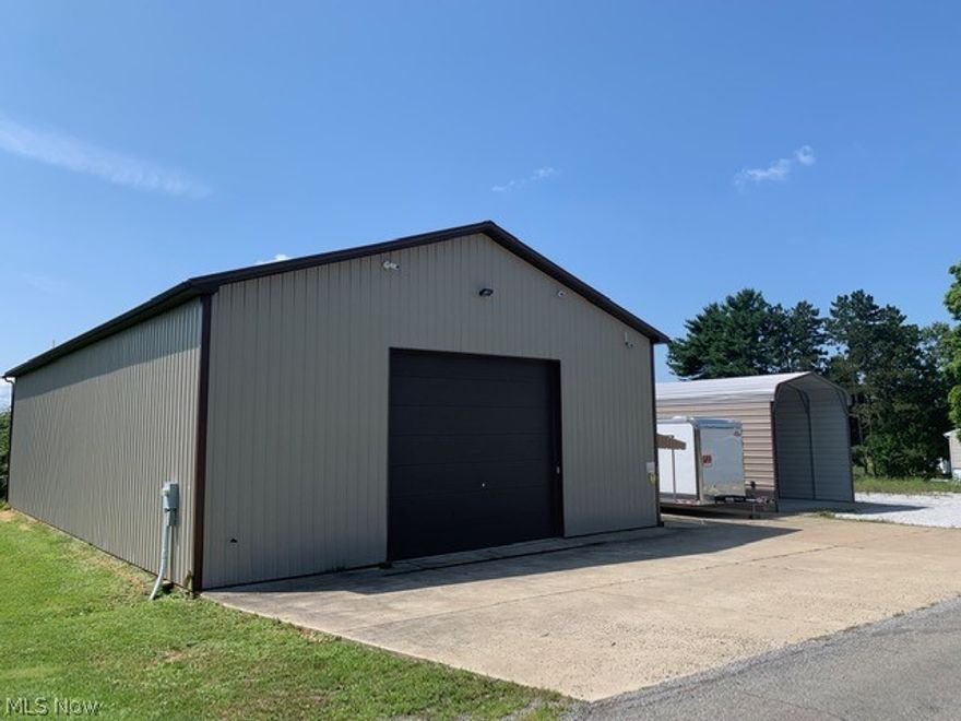 This is an immaculate well-built 80 by 40 garage with an 80 by 16 carport sitting on 3 lots in Wintersville.  There were no expenses spared in building these structures.  The main building has 3 commercial-grade 14 foot insulated garage doors with commercial openers.  The ceilings and wall are trimmed out in white aluminum and there is 14 inches of insulation in the ceilings as well as the walls being insulated also.  The concrete floors are well done with a third of the floors being 10 inches thick, a third being 8 inches thick and then the last third 6 inches thick.  There is plenty of lighting and 110 outlets around the complete interior perimeter.  There are two 50 amp service plugs and a propane furnace that is also piped for natural gas.  There is a restroom with hot water tank, a complete security system with cameras and video.  There is also an outside man door awning with a security gate.  The carport has concrete floors and there in additional concrete connecting the building