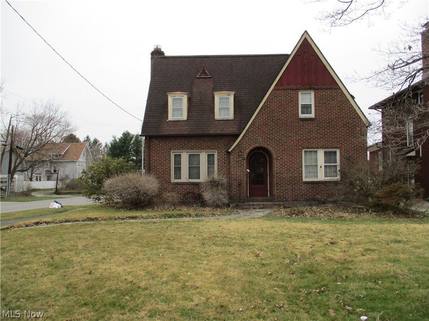 Traditional, brick, two story home with wood trim. Corner, city lot. Detached, 1 1/2 car garage has aluminum sided exterior and a concrete floor. Roof approx. 4-5 years old. Alcove entry with a chamber door. Foyer, guest closet, exposed stairs to the second floor. Large Living Room, cove molding, fireplace with mantle, original ceiling lights, French doors to the Sunroom. Formal Dining Room. Kitchen with linoleum flooring, appliances, older wood cabinets. Rear hallway. Hardwood floors throughout and some linoleum flooring. Window coverings are included. Second floor boasts three spacious Bedroom in the angled rooflines. Deep hallway storage closet. Unique Bathroom set-up. One room with commode and sink and another room with a sink and a shower. Full Basement with large storage room, fruit cellar with gravel floor, a separate laundry area, 100 amp elect. breaker box, gas-fired, hot water heat with a  boiler, gas HWT (approx. 2013). The price reflects the deferred maintenance required. A