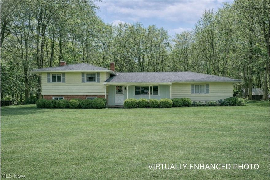 A Must See! Rare opportunity to own a truly unique home nestled on a private, wooded lot in Cuyahoga Falls. This 4-bedroom, 3-full-bath residence offers a versatile layout, architectural character, and versatile spaces seldom found in today's market - delivering exceptional value for the square footage and setting.

The main level features a comfortable living room and dining room, plus a large eat-in kitchen with glass sliders leading to a multi-level deck overlooking the backyard and wooded views - ideal for entertaining or quiet relaxation. A dramatic great room with vaulted ceilings sets this home apart and includes a built-in sound booth, perfect for musicians, podcasters, or anyone seeking a dedicated creative workspace. A main-floor laundry and full bath add everyday convenience.

The lower level expands the living space with a family room featuring a fireplace and sliding doors to a patio and backyard, creating seamless indoor-outdoor living. This level also includes a bedroom and full bath, offering excellent flexibility for guests, multigenerational living, or a private office. 
The basement offers a ton of storage space, unfinished space, a second laundry room and a unique room with a utility sink, perfect for crafting or the brew/wine maker.   

Upstairs, you'll find three generously sized bedrooms and a full bath, providing separation and privacy for the primary living areas.

Set on a scenic, wooded lot with mature trees and storage barn, this home offers privacy, functionality, and creative potential rarely available at this price point. A distinctive property that delivers space, character, and flexibility - ideal for buyers seeking something beyond the ordinary, all with in WOODRIDGE Schools.