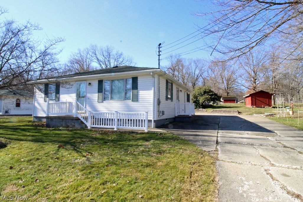 If you are looking for a ranch on almost 1.5 acres—here it is! Vinyl sided home has a great view of Wingfoot Lake across the street. There are 2 lots totaling 1.47 acres that is offered. A 48x32 outbuilding is located towards the back of the lot and has inside a 32x16 workshop that has a woodburning stove for heat and has electric. If you need storage this should do it! There are a couple other sheds on the lot for added storage. Behind the home is a 3-car garage with opener and electric. Both the front door and side door have small porches with vinyl railings. This used to be a 3-bedroom home. The owners had removed a wall to make an oversized bedroom. It would be easy to add a wall to split back into 2 separate bedrooms. The oversized kitchen has lots of cabinets and counterspace as well as plenty of room for a kitchen table. The living room is very bright and offers a view of Wingfoot Lake across the street. The home needs some TLC and is priced to sell. Being sold as-is.