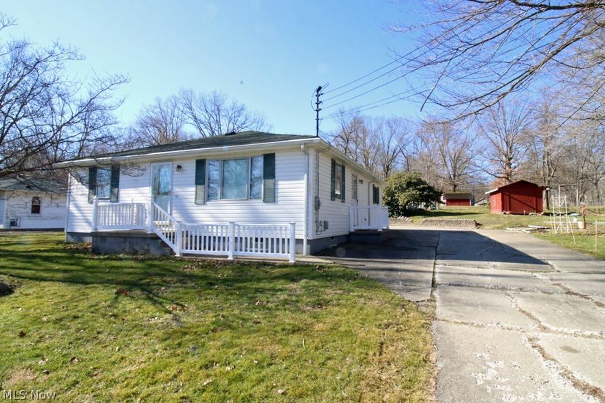 If you are looking for a ranch on almost 1.5 acres—here it is! Vinyl sided home has a great view of Wingfoot Lake across the street. There are 2 lots totaling 1.47 acres that is offered. A 48x32 outbuilding is located towards the back of the lot and has inside a 32x16 workshop that has a woodburning stove for heat and has electric. If you need storage this should do it! There are a couple other sheds on the lot for added storage. Behind the home is a 3-car garage with opener and electric. Both the front door and side door have small porches with vinyl railings. This used to be a 3-bedroom home. The owners had removed a wall to make an oversized bedroom. It would be easy to add a wall to split back into 2 separate bedrooms. The oversized kitchen has lots of cabinets and counterspace as well as plenty of room for a kitchen table. The living room is very bright and offers a view of Wingfoot Lake across the street. The home needs some TLC and is priced to sell. Being sold as-is.
