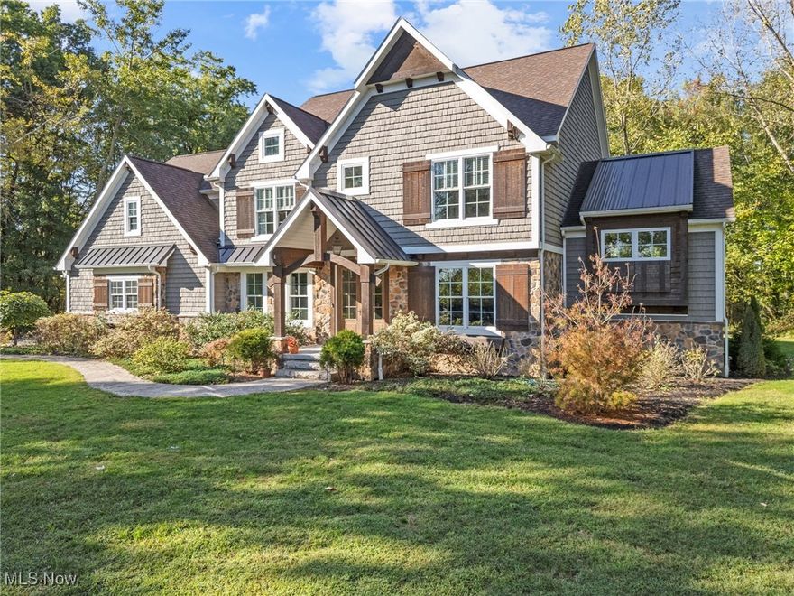 Set on 5 wooded acres in Lake Cable Farmlets, this custom Rembrandt-built home pairs everyday comfort with impressive spaces for gathering inside and out. The main floor welcomes you with a front office and a spacious great room featuring wood-beamed ceilings, a stone fireplace, and large windows that frame the natural surroundings. The kitchen is designed for both style and function, offering quartz countertops, stainless appliances, custom cabinetry, and a walk-in pantry. A bright dining area sits alongside, opening through a full bifold glass door to the patio with pergola and outdoor kitchen, perfect for indoor-outdoor living. A sun-filled family room wrapped in windows is the perfect place to start the day or unwind in the evening. A first-floor laundry and half bath complete the level. Upstairs, the primary suite offers a tray ceiling, dual vanities, a tiled walk-in shower, and a generous closet. Two bedrooms connect through a Jack-and-Jill bath, while the fourth has a full bath nearby. A large bonus room currently serves as a family recreation space and includes a built-in rock wall. Downstairs, the finished lower level transforms into a true retreat, offering a custom wet bar, theater room, guest suite, and full bath, perfect for game days, movie marathons, or overnight visitors. Outdoor amenities include a fire pit with stone seating, a bocce court, and a heated 30x40 carriage house capable of storing up to six cars or serving as space for hobbies or workshop needs, all surrounded by wooded acreage that offers both room to explore and the privacy of your own retreat. Additional features include an attached three car garage, tankless water heater, and 400-amp electrical service, all in a central Jackson location close to shopping, dining, and schools. Make an appointment to tour this dream home today!