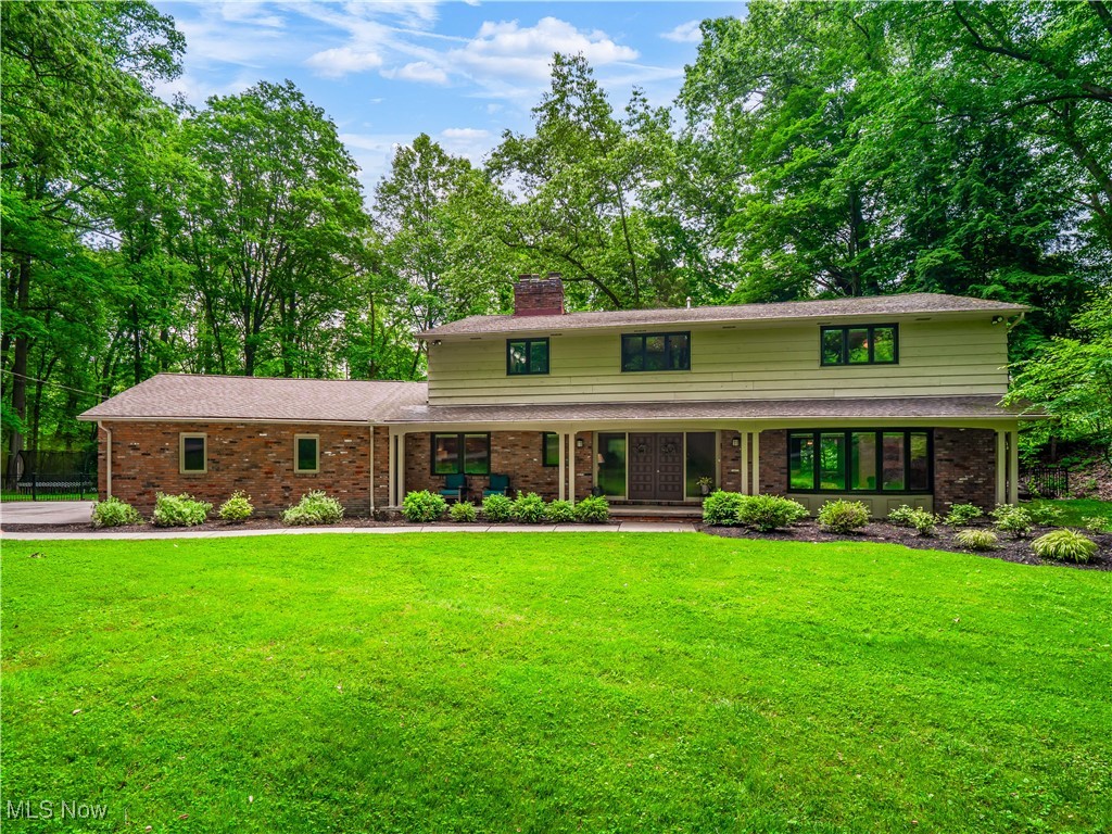 Welcome to your private oasis in Brecksville! Nestled on a secluded dead-end street and tucked away on 1.3 acres backing directly to Cuyahoga Valley National Park, this stunning home offers unmatched privacy, scenic views, and timeless elegance. Step through the classic mid-century modern double doors into a grand foyer featuring a circular staircase. To the left, enjoy a cozy private study with its own fireplace and half bath, perfect for working from home. A spacious formal living room with hardwood floors and a large bay-style picture window flows into the dining room through French doors—both rooms surrounded by wall-to-wall picture windows, bringing nature indoors. The heart of the home is the updated chef’s kitchen, featuring white shaker cabinets, huge pantry, granite countertops, stainless steel appliances, a cooktop with range hood, double ovens, tile floors, a wine fridge, and a beautiful tile backsplash. The kitchen opens to an eat-in area with peaceful views of the National Park, leading to a cozy family room with custom built-ins, a modern fireplace, and access to a custom-designed outdoor patio, ideal for entertaining. The first floor also includes a full bathroom and a well-equipped laundry room with ample storage. Upstairs, your luxurious master retreat awaits, complete with double sliding doors that open to a personal terrace, and sweeping views of the lush, fully fenced backyard and the National Park. The master ensuite boasts a walk-in closet, a double vanity, and a tile-surround shower, making this the perfect escape for peace and tranquility. Three additional oversized bedrooms and a beautifully updated full bathroom complete the second floor—two bedrooms feature private balconies overlooking the stunning backyard. The partially finished basement adds bonus living space. The true gem of this home is the incredible outdoor space—with multiple entertaining areas, flat green space for play, and breathtaking views year-round.
