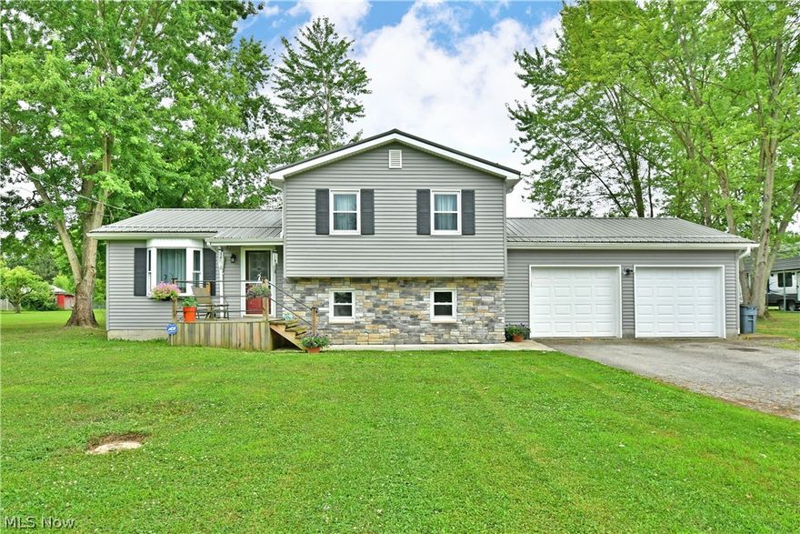 Heat up your summer with this smoking Mecca Township split level, on two acres of scenic property! The attractive home is quick to catch your eye with its bold, metal roof and charming stonework that accents the soothing white and grey exterior colors. Step through the decorative front door to find a bright and inviting dining room, peering through to the central kitchen via a large serving window. The updated kitchen itself is trimmed in an ornate, stamped metal backsplash that perfectly complements the like-colored cabinetry and stainless-steel appliances that stay. A coffee bar is enjoyed on the far side, set before a window-lined family room poised for all-season relaxation with its corner fireplace. Upstairs, three sizeable bedrooms provide plush carpets and personal closet space. The oversized master features an additional second closet within its ample layout. Completing the floor is a stylish and updated bathroom that engages the eye with its patterned tilework and bright white vanity. Downstairs, kick back and relax in a gracious lower-level living room with its beautiful stone fireplace. Around the corner, the spacious mudroom gives access to the attached two-car garage and the second full bath with a custom tiled shower. The basement has been professionally waterproofed and offers laundry services with washer & dryer staying, additional storage, a wood pellet stove (2021), and utilities. Updates include: metal roof 2017, vinyl replacement windows 2007, hot water tank 2018, well pump 2021, pressure tank 2023, main electric panel 2024, kitchen 2016, upstairs bathroom 2018, stone on the front of the house 2017, front deck & cement sidewalk 2021, and so much more! Plus a one year home warranty.