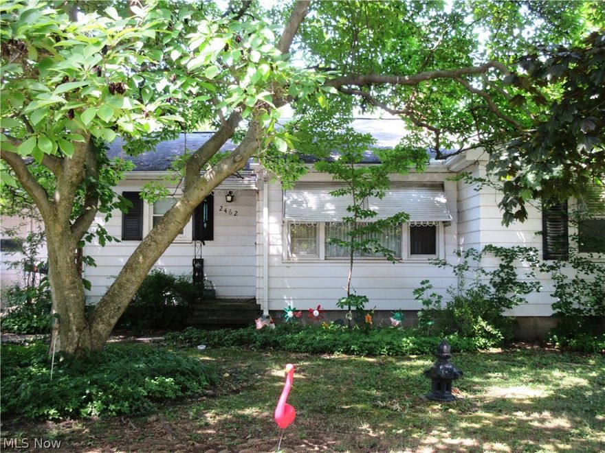 Cute little ranch in a nice shady location with mature trees and wooded in the back yard. This home is nestled in among all well kept homes.  Super location to everything, but tucked away. Home needs some TLC, but has good potential! Solid wood flooring throughout the house. Living room has rustic stone fireplace and is a good size for entertaining. Two good sized bedrooms with hardwood floors. One full bath in between the two bedrooms. There is a sun room off the living room with new roof. The kitchen is a good size with lots of cabinets- needs updating but has good space to work with. One car attached garage. Full basement. Very nice sized front lot! This property will be sold AS-IS, no repairs. Great investment property, or home improvement property for a buyer. Priced to leave room in the budget for updating this home!