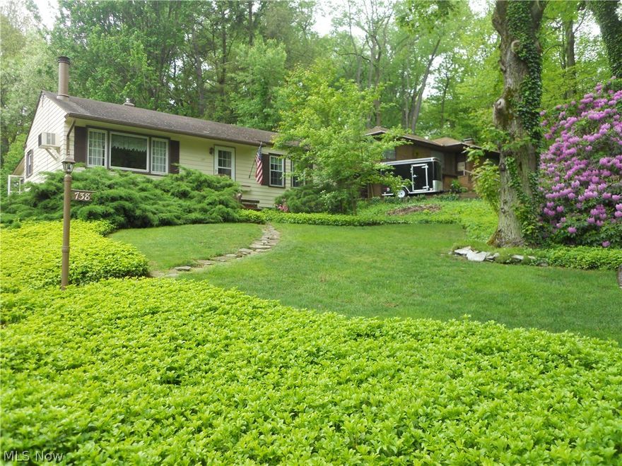 Welcome to this lovely raised ranch located near Portage Lakes. This home is nestled in a park like setting and features  3 bedrooms, 1 1/2 baths, nice large living room with gas fireplace, kitchen w/built-ins which leads to a spacious 3 season room over looking the private backyard. This home also features a large finished basement perfect for entertaining or play area. Lower level also includes utility workshop  which offers access to the garage. Hardwood floors under carpet on main floor.