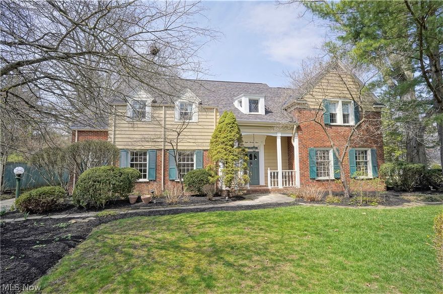 This stately Georgian Revival style Merriman Hills home boasts dormer windows & multiple gables. The flagstone walkway leads to the covered entry opening to the grand 2-story foyer w/marble flooring, turned staircase to the 2nd floor & dormer/alcove w/diamond leaded glass on the landing. The home is on a generous lot w/lush landscaping designed to offer privacy & a great view from the sunroom. A lovely stone wall graces the north side of the yard. The living room w/hardwood flooring, features a walnut-paneled Georgian-type fireplace. The front windows, side living room & library windows are original rolled glass to keep in line with the architecture. The dining room w/hardwood flooring leads to the breakfast nook near the kitchen. Between the 2 rooms are built-in cabinets w/leaded glass upper doors. The kitchen boasts white cabinetry, 2 pantry closets, solid surface countertops, built-in desk & center island w/butcher block top. The 1st floor has 8½’ ceilings. Arched doorways randomly