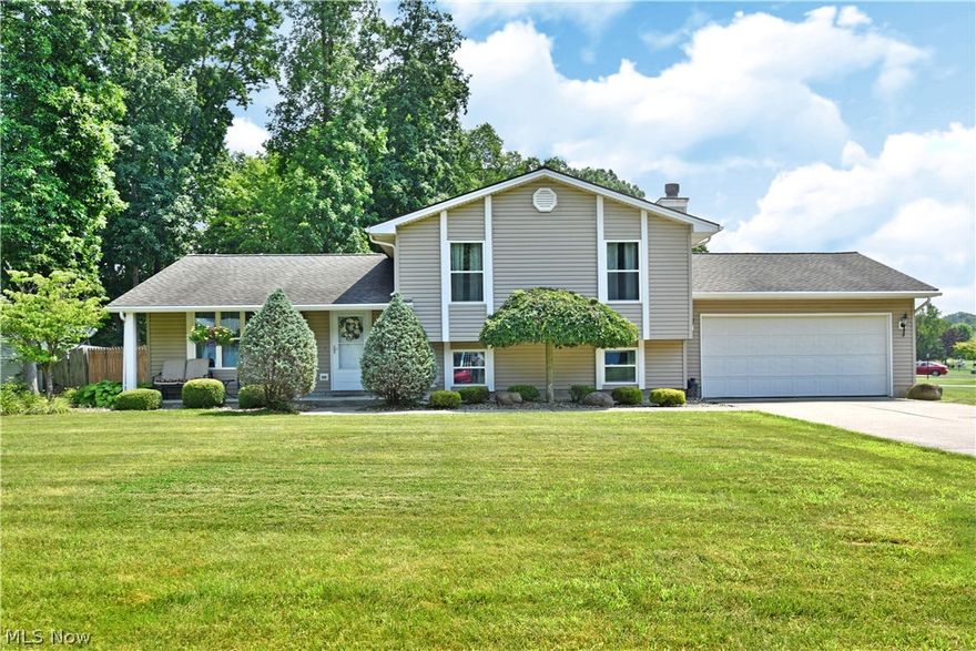 An absolute delight, hidden away in a quiet Canfield neighborhood, this gorgeous split-level wows with its beautiful modern updates and an open central floor plan waiting just inside. Placed on the inside of a curved lot, the prominent home stands out with its welcoming, covered front patio and unique exterior trim, all packaged with clean landscaping and a fenced in backyard with a relaxing deck space. Through the front door, the great room instantly draws you near with ash colored flooring and a stunning kitchen complete with large island, basin style sink, stainless appliances and faux brickwork serving as an elegant backsplash. Recessed lighting joins a skylight to provide the sunshine as sliding doors await the rear patio. Upstairs, a trio of carpeted bedrooms include an oversized master suite with full private bath and dual closets. An additional full bath showcases sundrenched tile with its additional skylight along with a bespoke tub and shower surround. Downstairs, a brick fir