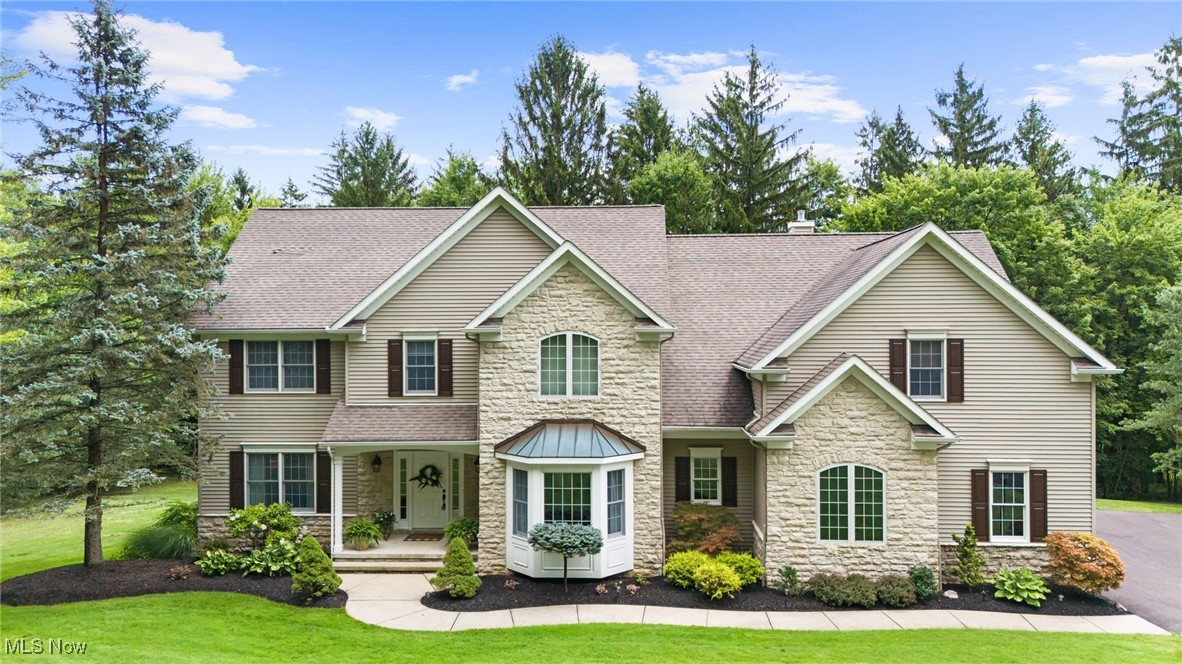 INCREDIBLE Custom Built Home situated on 2.5+ Private Wooded Acres and borders Chardon Lakes Golf Course! Builders personal home was thoughtfully designed and quality-built with over 5800 sqft of finished living space, gorgeous woodwork and tasteful neutral decor throughout! The covered front entry and foyer welcomes you with hardwood floors and opens to both Spacious Formal Dining Room and Living Room. Vaulted Great Room with wall of windows, gas fireplace flanked by built-in bookshelves/cabinetry and 2nd staircase to upper level. The Gourmet Kitchen is beautifully appointed with abundance of cabinets, granite counters, breakfast bar, newer stainless steel appliances, built-in desk, pantry and hardwood floors. Bright & light Breakfast Room with vaulted beamed ceiling & sliders to 3-Season Sunroom to enjoy peaceful views with your morning coffee. Retreat to the Master Bedroom Suite with fireplace, walk-in closet & Remodeled Master Bath with tongue & groove wood ceiling, double sink granite vanity, oversized ceramic spa shower & freestanding soaking tub. Second floor also includes 3 additional generous sized bedrooms with great closet space & full bath to share. 1st floor laundry room, mudroom and half bath complete the main level. Finished walk-out lower level is made for entertaining with a large Rec Room and bar, with wall of windows and patio access, built-in media center, gaming area, bath, separate office and walk-up garage access. New high-efficiency furnace 2025 & HWT 2024. Relax or host on the multiple stamped concrete patios overlooking the beautifully landscaped yard with manicured beds, lush plantings & surrounded by mature trees for added privacy. 3+car attached garage with freshly paved driveway. Meticulously maintained inside & out...must see to appreciate all this home has to offer!