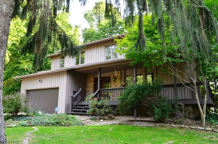 Wonderful colonial, nestled on over half an acre in Copley Township, presents spacious living areas throughout and private wooded backdrop!  Welcoming, covered front porch connects to wraparound deck and glass double doors lead to front foyer.  Gracious living room highlights ample windows and opens to formal dining room with bay window.  Custom chef's kitchen boasts center island/breakfast bar, SS appliances, pantry, and extended cabinetry with built-in wine rack.  Separate eating area with walls of glass and access to deck.  Engaging family room features floor to ceiling stone fireplace flanked by windows.  Glass French doors lead to vaulted great room with slider to patio and panoramic views of property.  Guest bath conveniently located.  Spacious, vaulted master suite presents sitting area, private bath with tile shower, large walk-in closet, and adjacent, glassed in bonus room (currently used as office).  Three additional, generous sized bedrooms and main bath complete the second