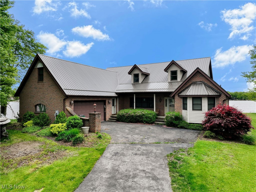 Beautiful HUGE Lakehouse with panoramic views from the 220' of shoreline on the north end of the lake. The exterior includes great entertaining space along with a protected boat slip, large deck, and a walk out basement. The all brick home features roughly 4300 square feet of finished space including 5 bedrooms and 5 baths. 3 of the bedrooms are set up as Master suites(1 on the main floor) which is great if you have a large family or overnight guests. Also, all of them have a beautiful view of the Lake. The eat-in Kitchen has Brazilian cherry cabinetry, Granite counters, and matching built-in appliances. The Main floor has an open living room, formal dining room and french doors that lead to a 4-season/sunroom (currently used as an office). The lower level is mostly finished. It walks out to the boat slip area and features a second kitchen, family room, and a full bath. Some of the unfinished storage area could easily be finished into another bedroom creating an extra living suite! Paradise Bay restaurant/bar is just a few hundred yards away as is the Marina. Seller will consider a flooring credit to replace worn carpet with an acceptable offer.