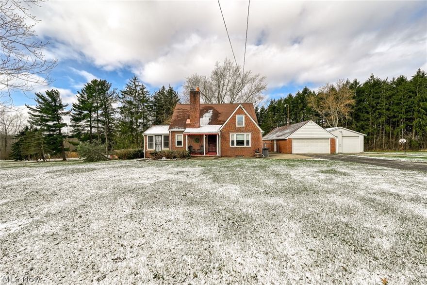 Welcome to this charming Cape Cod nestled on a 3 ACRE setting - offering the perfect blend of character, space, and modern updates!  Whether you are a hobbyist, car enthusiast or need extra storage, you'll appreciate the 4-car garage with separate garage doors with openers, and a 31x30 outbuilding. Step inside and fall in love with the warmth of beautiful hardwood floors, timeless built-ins, soft arched doorways and the unique charm you simply can't replicate. The home has been thoughtfully updated with vinyl windows, Kitchen and both bath remodels 2023,  all kitchen appliances 2023, washer and dryer 2023, basement flooring 2026, stylish window blinds throughout 2023, replaced chimney flue liner 2025, furnace and a/c 2023. This home is truly move in ready! Relax by the gas fireplace in the large living room or step into the all season sunroom ready for reading, a home office, or hobbies. The basement offers even more finished living space with a large laundry room and two separate finished rooms ready to use for whatever needs you have, whether it be workout room, another bedroom, den? The basement is walk-out. The back door and the basement door will bring you outside to a wonderful covered patio and fenced (chain link fencing replaced 2023) rear yard perfect for entertaining rain or shine. The home is located on a corner lot and lined with trees to the rear giving you privacy from neighbors. Great opportunity to have a beautiful home, 3 acres of land and plenty of garage and driveway space for all of your necessities!!