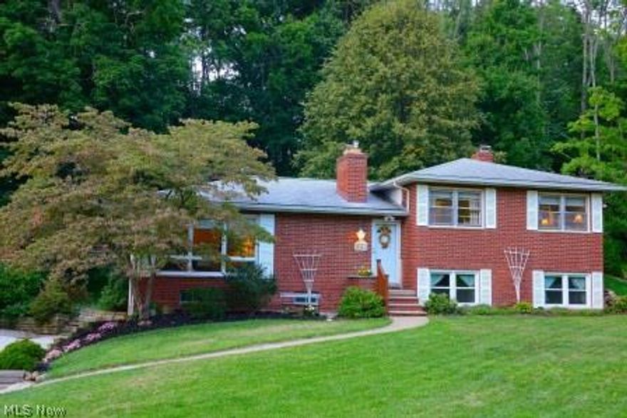 All Brick Split-Level with 3 Bedrooms and 2 FULL Baths, on a beautiful treed lot! Dining Room with hardwood floors. Large Kitchen with desk and 2 pantries. Gorgeous corner of windows in Living Room with wood floors and Stone Fireplace.  Screened Porch off Kitchen and Family Room with wood-burning Fireplace! (Fireplace was previously Gas) New water softener, updated insulation, well pump and septic.  Kitchen and downstairs Bathroom remodeled. New windows for ALL Bedrooms, Baths & Rec. area.  2 Car Garage with extra storage. Relaxed living in this quiet neighborhood, close to schools, shopping/Mall and with easy access to Akron/Cleveland via I-77.  Home Warranty Included.