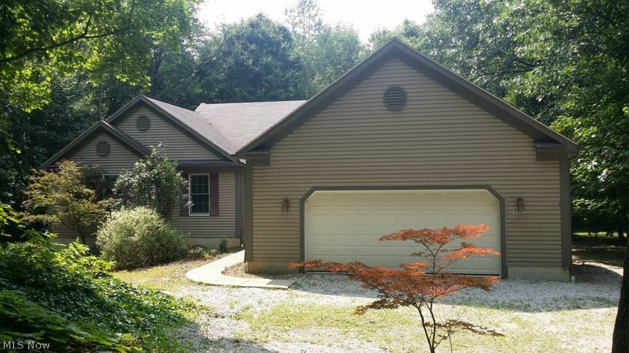 Step saving vinyl sided ranch on private wooded 1.6 acre lot.   Open floor plan features great room with vaulted ceiling opening to spacious eat in kitchen with access to extra large deck overlooking heavily wooded backyard.   Owner's suite with access to deck features master bath with soaking tub and separate shower and walk in closet.   1st floor laundry.  Full walkout lower level could be easily finished and is roughed in for half bath.   2 car attached garage.   Extra large outbuilding perfect for mechanic and or car collector or boat storage!   Great location seconds away from Portage Lakes State Park!