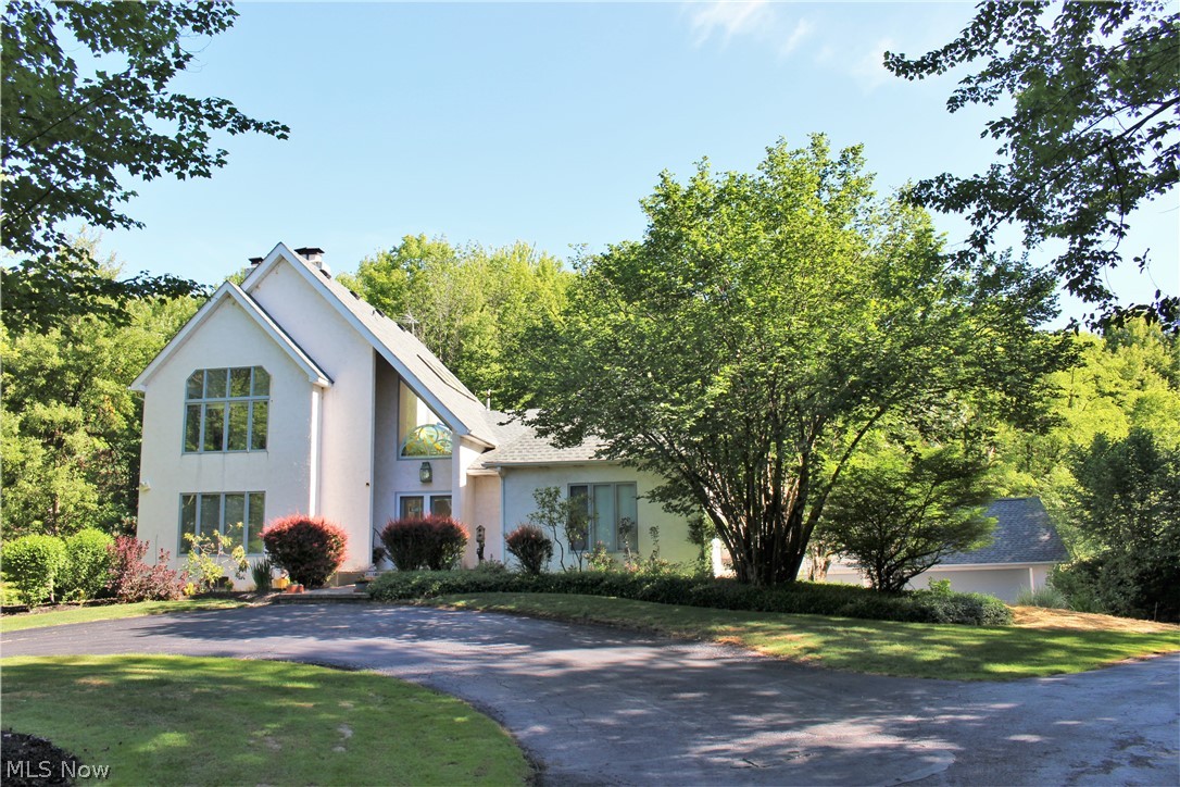 Set back from a private road, this home offers privacy and seclusion for those who desire it. Once inside, enter through an open 2 story Foyer, to the formal LR with a stone fp, & beautiful views through the picture window of the yard & pond. A semicircular wall separates the LR from the Formal DR, also with great views. Your private office with built ins & a fp beckon you. The kitchen was remodeled, adding black granite countertops to custom built cabinets & a center triangular island with a Breakfast Bar, all illuminated by 6 skylights. Unique see through cabinets were designed to view the pond & yard. Enjoy your cup of coffee every morning in your glassed Solarium with marble floor. There are 4 1st flr BDs, 1 could be a 1st flr Master Suite with a full bath. Moving up to the 2nd flr with loft by the custom designed staircase, we enter the Master Suite which encompasses the entire 2nd flr. It includes a gas fp, sitting rm, nursery, or exercise rm with 2 walk-in closets & priva