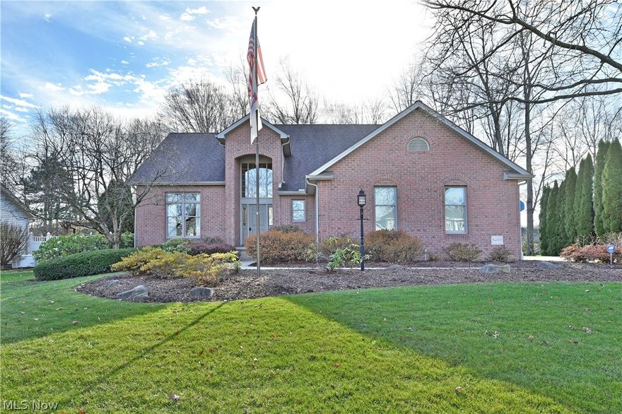 Find more than meets the eye with this prominent Austintown home, as it offers a massive 5 bedroom layout to include a separate in-law suite! Manicured landscaping wraps the towering brick front as the covered two-story entrance showcases impressive glasswork that fills the foyer with natural light. Around the back, a sizeable deck delights with a powered awning that extends out for shade as you take in the scenic wood line. Inside, a wood-trimmed staircase rises from the tiled landing. The carpeted great room sweeps past w/ its tall 10ft ceilings, and bay window-lined dining area. The glass tile-filled kitchen completes the look at the far wall w/ its custom cabinetry, granite countertops, stainless appliances, & large island w/ seating. The sliding glass door beset the rear deck as home office space transitions down a dividing hall w/ a pass-through half bath. The 1st floor laundry is located near the in-law suite entry and attached three-car garage. The in-law suite opens w/ a gener
