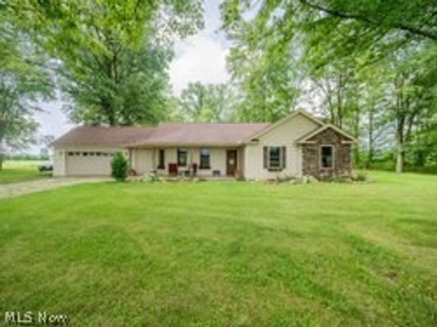 Custom crafted, young ranch sitting on a peaceful 1 acre wooded lot. Welcoming front porch with wood and stone posts and room for several rockers to enjoy the country view. Open floor concept with vaulted ceilings throughout the living, dining and kitchen areas. Hickory wood work adds to the rustic feeling of the property. The living room features front windows that overlook the porch and great space for a sectional sofa and more. The dining area can easily seat 6-8 people and has a slider door to the backyard and patio. The expansive patio is perfect for dining alfresco and has a firepit for cozy starlit nights. The kitchen includes lovely cherry cabinets, a black granite sink, stainless steel appliances, a nicely sized pantry, a workstation and a breakfast bar. Awesome mud room right off the garage with a wood feature wall and room to store all your coats, shoes and boots. The master bedroom suite includes a large walk-in closet and an in-suite bath with dual sinks, granite counter t