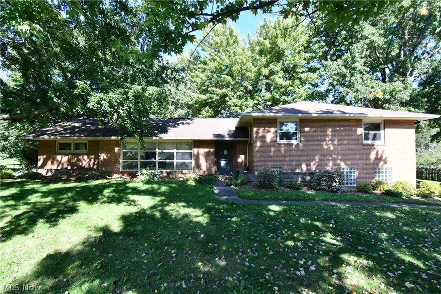 True mid-century modern brick 4 level split on .6953 acre lot at 125 Tonawanda Trail in the Village of Hartville Ohio. Spacious living room offers a wall of windows allowing an abundance of natural light and giving panoramic views of the treed front yard. The formal dining room opens to the living room.  Updated kitchen with stainless steel appliances and a dinette area. Charming and cozy den features a stone fireplace and knotty pine walls. A first floor laundry/mud room has a shower and access to the backyard. Cathedral ceiling in the sun room which looks out onto the treed back yard. A family room with heated floors has its own access to the back of the house. The second floor master suite includes a large ceramic tile shower. Two additional bedrooms and another full bathroom complete the second floor living space. There is additional living space in the finished basement with an office, recreation room, a possible bedroom, and a huge craft room featuring built-in cabinets, a sink and loads of counter space. The attached 2 car garage has heated floors, a second laundry area, and a bathroom. There is a two car detached garage with electric and taller overhead doors. The park like backyard offers an above ground pool with deck.  Immediate possession!