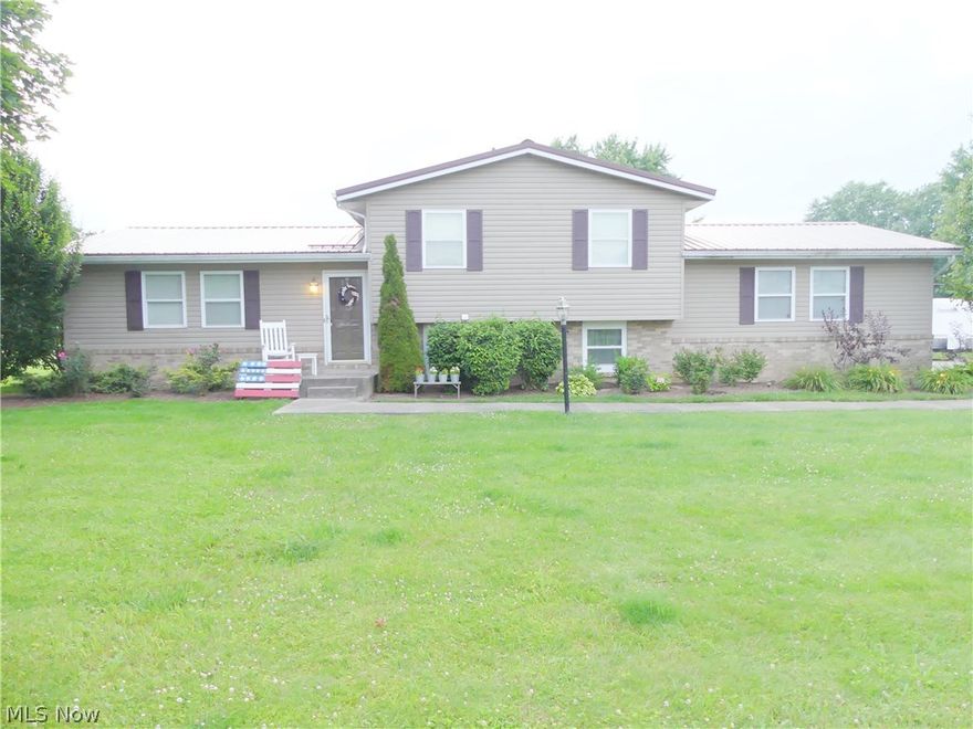 Wow!  This home is out of a magazine!  It is darling, you have to see it in person.  Beautiful lot with an amazing view of the country side.  So many updates...new metal roof in 2013, remodeled living areas...all open and great for entertaining.  New water softener and newer septic 200 gallon holding tank and 250 gallon lift station.   Well pump is only a year old.  Nice sized bedrooms and the lower level offers a family room or even a playroom for the all the kids' toys...many uses.  The enclosed back porch allows you to enjoy the gorgeous view, no matter the weather.  Nicely maintained and updated, just move in and enjoy.