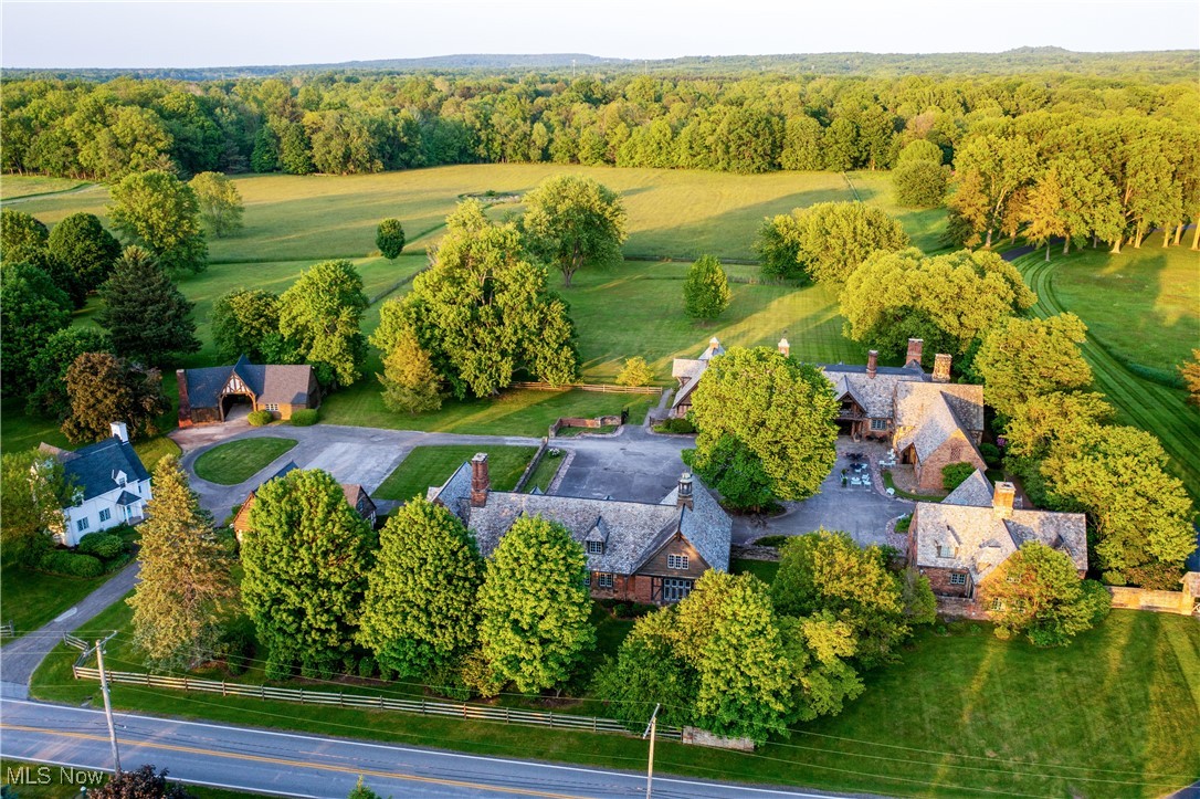 Set across 27 sweeping acres in prestigious Waite Hill, 9391 Hobart Road is more than a home—it’s a lifestyle compound with limitless possibilities. Gated and grand, the English Country Estate unfolds from a genteel cobblestone courtyard into a private world of historical allure, architectural richness and pastoral beauty. At the heart of the estate is a one-of-a-kind residence, masterfully transformed from an original stable into a sophisticated English Tudor with striking scale, rich textures, and incredible historical details like hand-hewed beams, hand-chiseled stone, leaded glass windows and original wrought iron fixtures. Two additional guest cottages—The Stone Cottage and The White House—provide flexibility for extended family, guests, or creative use. An eight-car garage, dairy barn, two-story indoor squash court, blacksmith’s shop, and tractor barn offer incredible infrastructure for equestrian, agricultural, or bespoke lifestyle pursuits. The grounds are nothing short of breathtaking—over 27 acres of open pastures and fence-lined fields create an atmosphere of peace, privacy, and potential. Whether your vision is a multi-generational retreat, a working homestead, or a showstopping primary residence, this incredible enclave offers the unique foundation to bring it to life. This extraordinary estate has been chiseled by history and is now ready for its next chapter to be crafted by your imagination.