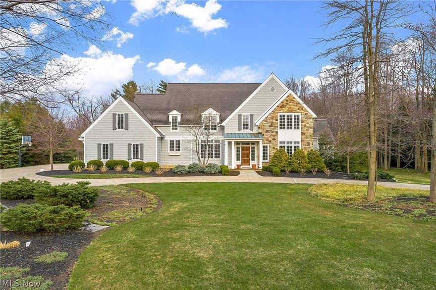 A circular driveway leads to this amazing stone and cedar home in a convenient and sought after location with hardwood floors throughout. The foyer welcomes you into this home with tasteful fixtures and plenty of open space. Leading between two pillars is the great room with a wall of built-ins, soaring windows and vaulted ceiling! The spacious eat-in kitchen with cherry cabinets and granite counters has high end appliances and recessed lighting. Attached to the kitchen is the 1st floor laundry, a half bath, and the attached 3 car garage. The dining room has tasteful lighting and  wall of windows creating a bright space overlooking the front yard's hydrangeas. The bonus living room is a nice quiet place separated from the openness of the great room and leads to the 1st floor master bedroom. The master with vaulted ceilings, tall windows and fireplace leads to an incredible marble master bath with deep tub, walk in shower and double vanity sink. The 2nd floor features a private office a