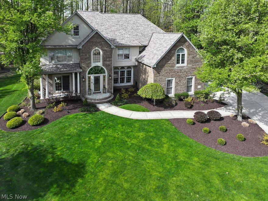 Welcome to this pristine, well-maintained home filled with custom high-end finishes throughout in a desirable Mentor location. This home features 6 bedrooms, 5 full baths, with over 5,000 sq ft of living space. The grand entryway welcomes you into this beautiful home with a formal living room and a dining room adorned with decorative pillars and a chair rail. The sunlit great room, boasting hardwood floors, features soaring windows with custom blinds and a full stone double-sided gas fireplace. The eat-in kitchen, complete with bar top seating, showcases granite countertops, all appliances, over and under cabinet lighting, and a pantry. A breakfast nook with a bayed window allows for easy access to the outdoors, perfect for entertaining. A bedroom (office), full bath, and laundry room complete the first floor. Five bedrooms are located on the second floor, including the primary en-suite, which boasts a bayed window, stone gas fireplace, spa tub, walk-in shower, and double sinks. Two bedrooms are connected with a Jack-n-Jill bath, while another is an en-suite. The lower level, featuring new carpet, is fully finished with a wet bar, recreation room with theater seating, workout room, full bath, and large storage area. Enjoy family time outdoors in the over 3/4 of an acre wooded backyard, large wood deck, and paver patio. Professional, mature landscaping includes a 7-zone irrigation system, custom outdoor lighting, shed, and invisible fence. A new roof with 6" gutters and guards was installed in 2021, along with a new furnace/A/C and hot water tank in 2019, and new garage doors in 2022. Conveniently located near parks, shopping, restaurants, and highways, this home is truly a must-see!