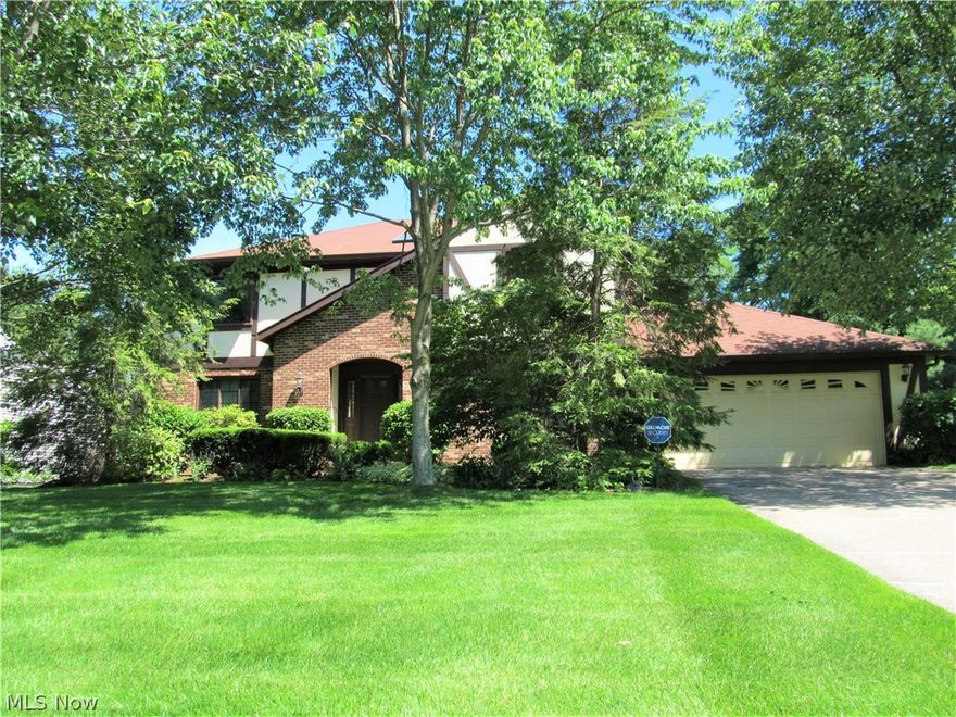 Town Park, Tudor style colonial in the heart of Solon -  convenient to schools.  Enter the home through the 2-story foyer with ceramic tile floor, flanked by twin closets.  Formal living room with crown molding; dining room with crown and chair rail.  The kitchen boasts plentiful cabinets and counter space, plus newer stainless refrigerator and stove.  The jewel of the kitchen is the center island with gorgeous granite top and newer light fixture with a hide-away ceiling fan [remote controlled].   The eat-in area has a sliding door to the deck with lovely view of the wooded yard.  Family room with brick fireplace and wet bar – perfect for relaxing and entertaining.  First floor powder room and laundry.  On 2nd floor, double doors open to the enormous master bedroom with private bath.  3 other spacious bedrooms and main bath. Unfinished basement, 2-car garage, whole house generator, security system, newer windows and patio door.  Home has been lovingly cared for and waiting for new owne