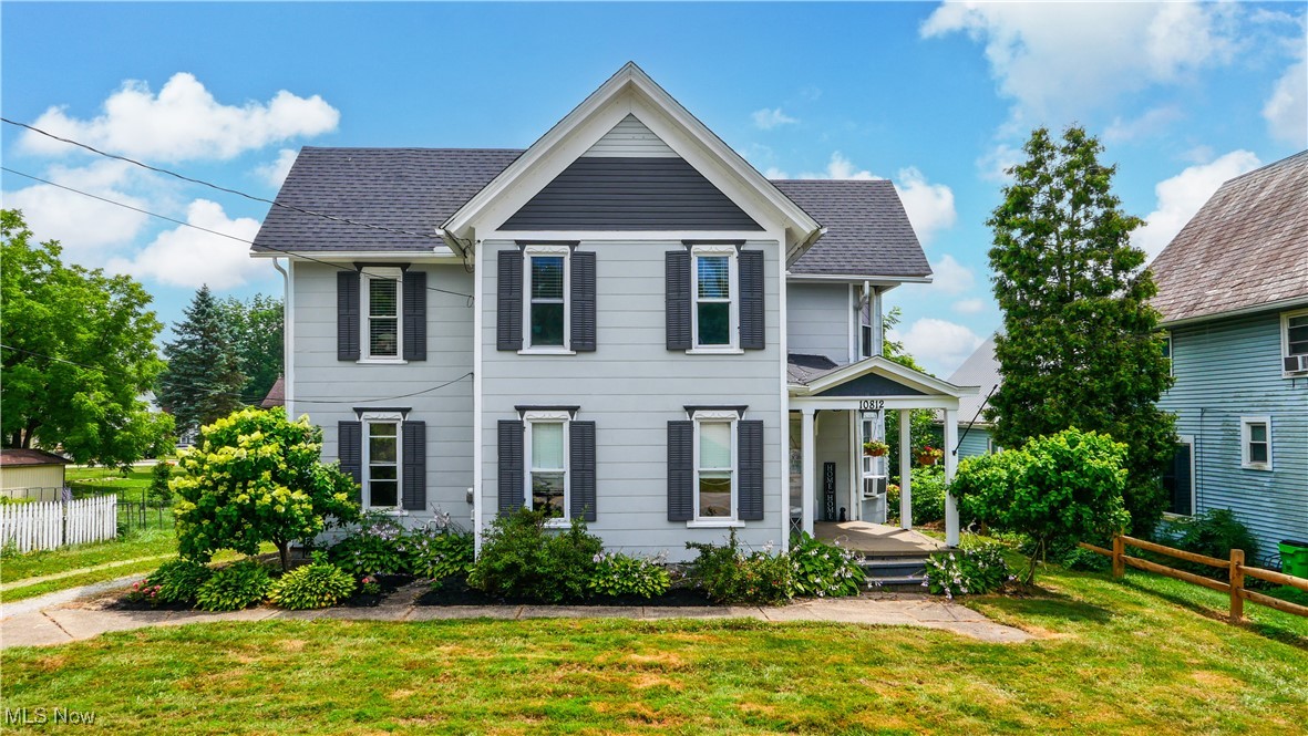 Charming century home perfectly blending historic character with modern livability. The inviting front porch sets the tone for this beautiful residence, featuring an open entry and living area that flows seamlessly into the family room and formal dining room, all showcasing stunning hardwood floors. A unique half bath with decorative chair rail and accent wood ceiling adds a touch of elegance. The spacious kitchen boasts charming features such as exposed brick, open glass cabinets, and a convenient coffee bar/work station, making it the perfect space for cooking and entertaining. Additional first-floor amenities include a practical laundry room and a mudroom leading to a large back deck. Upstairs, an exquisite curved staircase leads to three generously sized bedrooms and a full bathroom. The property also features a detached two-car garage with walk-up attic and electric, as well as a large fenced-in backyard. Conveniently located near local amenities, this home offers the ideal balance of charm and functionality.