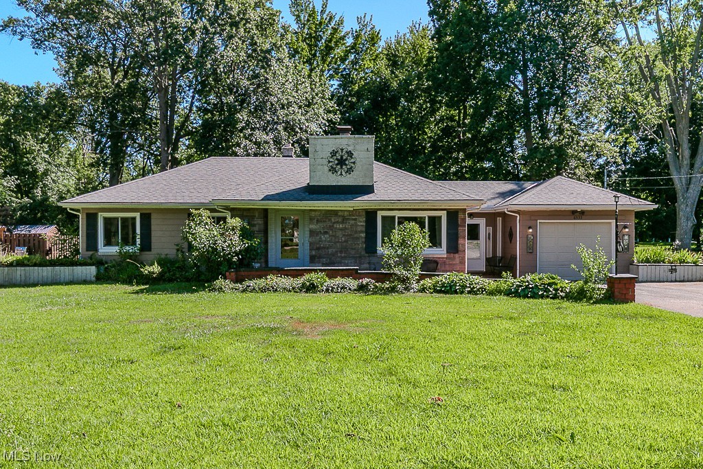 Welcome to 6533 Coleridge Road, a warm and inviting true ranch-style home situated on a peaceful half-acre lot in one of Concord Township’s most desirable locations. Offering over 1,700 square feet of thoughtfully arranged living space, this home balances charm, comfort, and functionality. An oversized driveway and spacious front paver patio with dual entrances create a welcoming approach and provide ample room for everyday convenience and guest parking. Inside, a generous front living room greets you with abundant natural light through a large picture window, complemented by a classic brick wood-burning fireplace and a cozy built-in nook with custom bookshelves — perfect for reading or quiet moments. This home has been well cared for and offers a warm, lived-in character throughout. The kitchen connects easily to the dining and family room area, with a large pass-through window and sightlines that make entertaining or everyday meals a breeze. A glass slider leads to a bright and cheerful 200-square-foot sunroom, providing year-round views of the private, wooded backyard. Just outside, a small deck and patio are enclosed by a wood privacy fence — an ideal space for gardening, grilling, or simply enjoying the outdoors. Two bedrooms and two bathrooms round out the home, along with a laundry room and attached garage. With its functional layout, welcoming atmosphere, and a setting that blends natural beauty with neighborhood charm, this home is a rare opportunity for those seeking simplicity, space, and character in Concord Township. A truly special place to call home.