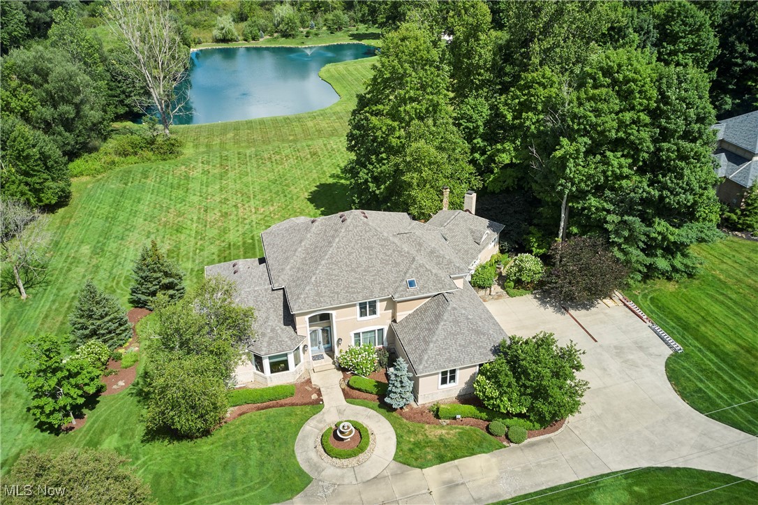 Discover your dream home in Arbour Green, situated on a picturesque 1.5-acre lot within the desirable former Bath Golf Course community. Custom-built in 2001 and a new roof was added in 2024, this 5 bedroom, 5.2 bath residence offers a blend of elegance and modern convenience. The main level features a spacious first-floor owner’s suite. The heart of the home is the chef’s kitchen, showcasing quartz countertops, a large center island, Wolf Range, and a custom pantry. Expansive Great room with a wall of windows, tall ceilings, wet bar, and access to the deck is perfect for entertaining. Walk down to the outdoor fireplace and enjoy the water views and large, flat backyard. Also, enjoy the family room w/fireplace off of the kitchen. Formal dining room, private office, and a convenient laundry/mudroom complete the main floor, along with two half baths for guests. Upstairs, you’ll find 3 en suite bedrooms. Over 1,000 sq feet in the finished lower level offers versatility with a 5th bedroom suite. full bath, family room featuring a fireplace, and a workout room; all with walkout access to the flat backyard. Additional features include a kids' playhouse, and side-loading three-car garage, and the convenience of public sewer. Generator (2023), New HVAC (2024 & 18), New A/C (2022 & 19). New Driveway (2025). New Carpet (2025). Indoor & outdoor audio system. Located in the top-rated Revere School District and just minutes from Montrose shopping, this home offers both luxury and practicality. Schedule your private tour today to experience the charm and elegance of this exceptional property firsthand.