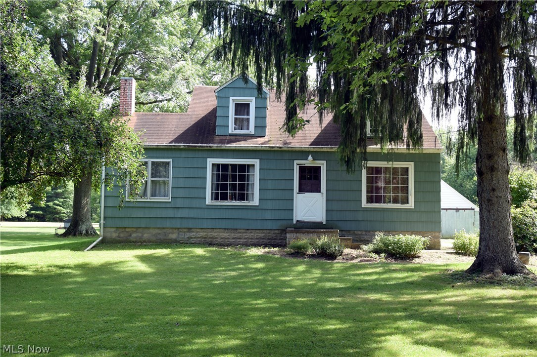 Tons of character and charm awaits you in this cozy cape-code home that sits on almost 3 acres of land. The property is lined with fully mature pine trees. Once you step inside, you'll find the home has its original hardwood floors throughout that are in perfect condition and gorgeous cherry Kraftmaid kitchen cabinets. Also on first floor is the master bedroom. The home has a newer roof, windows and electric. Two bedrooms and one full bath are on the second floor. The four car detached garage (32x56) has its own private bathroom, heat and electric. The upstairs loft area of the garage can be converted into an apartment for extra rental income, storage or a "man cave." Don't let this home pass you by.