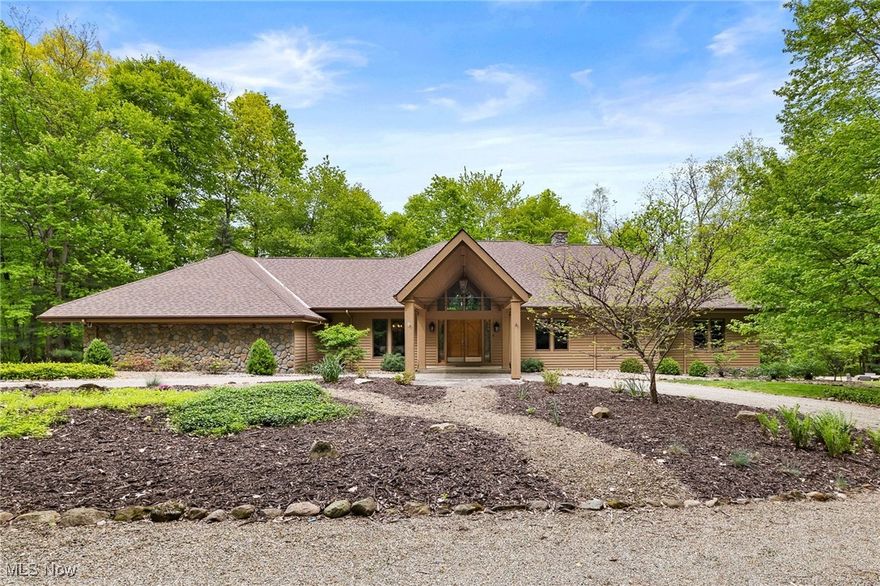 The perfect blend of spacious luxury and serene privacy in this stunning 3,180 sq ft ranch, complete with a finished walk-out basement, nestled on 7.9 acres of beautifully wooded land. Step into the grand foyer that leads to a breathtaking great room featuring a wood cathedral ceiling, a cozy stone wood-burning fireplace, and expansive glass windows/doors that open onto a deck offering tranquil, picturesque views. Master suite is a true retreat w/an updated bath boasting double sinks, a dual shower, 3 walk-in closets, and direct access to the deck. Basement includes a family rm, rec rm, full bath, 2nd kitchen, providing ample space for entertaining. Outdoor living at its finest with a full covered kitchen equipped w/ a grill, cabinets, sink, and stone countertops. Additional highlights include a 3-car outbuilding w/ water, heat, walk-up storage!