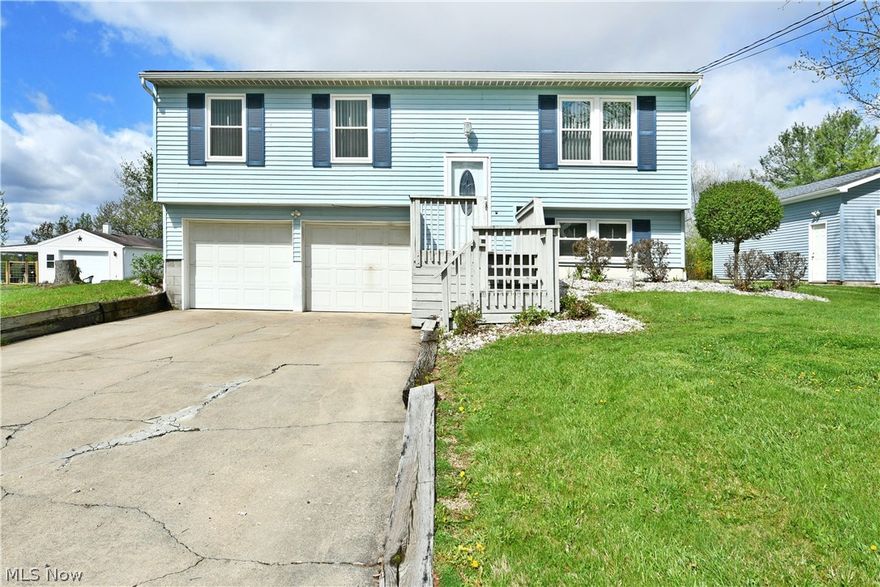 A special treat, right in the heart of Champion, this raised ranch bi-level home ups the attraction level with two lots, a huge external garage and a wonderful, privacy fence lined backyard with a raised rear patio plus a bonus storage shed! Bright blue colors create an instant attraction, all while the winding front stairway rises from the concrete drive and two-car attached garage for a possible six car total. Through the decorative entry door, the carpeted staircase rises from the foyer to find an inviting living room, basking in the natural light of its large picture windows. Carpeted flooring runs underfoot as the wood trim work extends into the nearby dining room where hardwood styled flooring transitions in as more sunshine spills from the sliding doors leading to the rear deck. The central kitchen offers additional casual dining options with its multitude of wood finish cabinetry. Stainless appliances add a splash of bright work. Down the main hall, a boldly painted full bath joins the trio of spacious, carpeted bedrooms. The oversized master suite includes additional closet space and its own full private bath with stall shower. Downstairs, a finished family room joins utilities, laundry, and a standalone commode. Call Today!