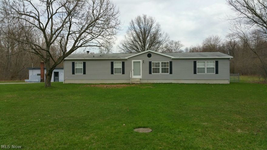The seller is downsizing and is selling her 3 bedroom house, which she purchased new in 2002, with full basement and detached 4 1/2 car garage, all located on a 1.64 acre lot in South Range School District.  The house, built in 2002, is a 28'x 60' Commodore manufactured house on a 12 course block basement with covered walkout doorway, and an attached 24'x 12' wood deck.  There is a heated 40'x 26' three car concrete block garage/shop with three 10' x 8' OH doors with openers and an attached 20'x 16' garage with an OH door.  In front of the garage is a large slag parking lot.  The property has been well maintained and the house is in like new condition. Exterior walls are 2"x 6" with R-19 insulation and the ceiling is insulated to R-31. Kreps Road has very low traffic volume.  Come see for yourself.