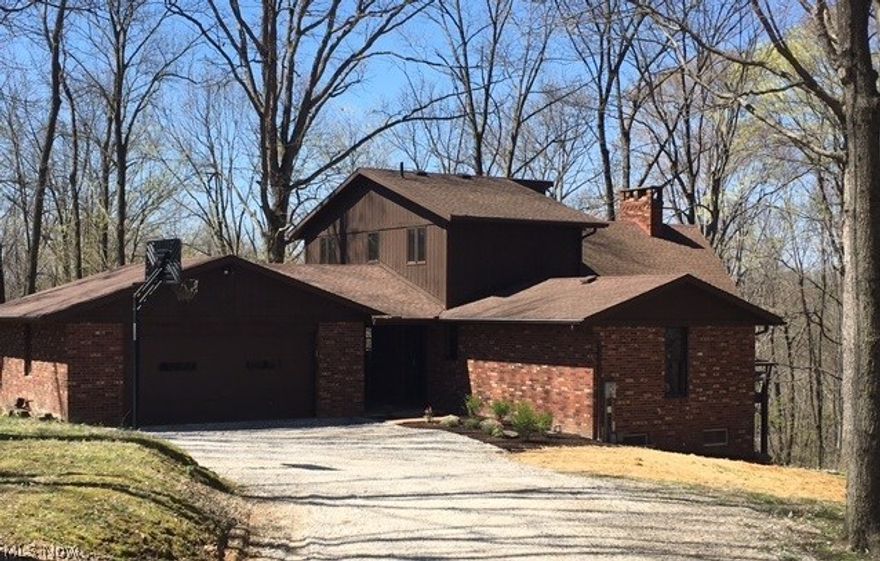 First time offered on the market. This outstanding home is situated on a beautiful 2.5 wooded acres and has a great wraparound deck with amazing views. This 3 bedroom home has 2 full bathrooms and 2 half baths. Completely new kitchen with granite countertops and stainless steel appliances, new floor coverings throughout, lighting fixtures and freshly painted. Impressive Great room with 18-foot beamed cathedral ceilings and 2-story stone fireplace. Finished walkout lower level includes living room with wood burning fireplace, wet bar, pool table area and a covered patio. All this situated in Wilkshire Hills with public water, public sewer and Columbia Gas. Agent Owned.