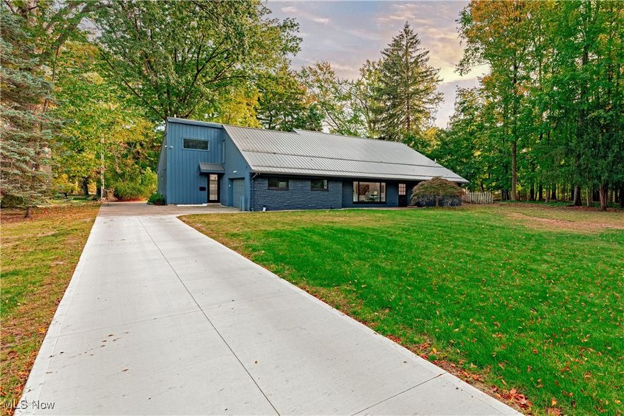 Designed for those who appreciate the finer things in life, this exquisite residence has been completely rebuilt into a cohesive contemporary masterpiece. Offering over 4,100 square feet of living space, the home features soaring ceilings, clean architectural lines, gallery walls, and expansive windows that frame the serene grounds—perfect for a collector or artist seeking a refined live/work environment. The original ranch-style layout has been thoughtfully expanded to create an open-concept design with seamless indoor-outdoor flow and effortless access to the park-like setting. At the heart of the home, the chef’s kitchen impresses with top-of-the-line appliances, striking granite counters, and custom cabinetry with built-in organizers. The vaulted great room opens through a wall of sliding glass doors to an exceptional deck surrounded by lush foliage, creating an ideal space for open-air entertaining and year-round views. The primary suite offers a spa-like bath, a walk-in closet, and French doors leading to a private screened-in porch. Two additional bedrooms are located on the main level, while a fourth bedroom suite occupies the upper floor, offering flexibility for guests. Each living area showcases high-end finishes and thoughtful details, including custom built-in storage and an art hanging system designed for displaying pieces of any scale. Perfectly situated just minutes from downtown along the Bratenahl coast, this remarkable home offers easy access to University Circle, world-class museums, and all area amenities.