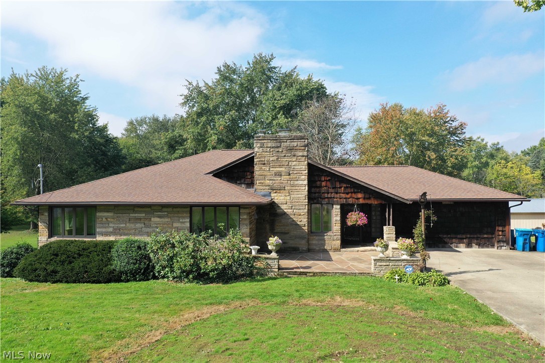 Welcome to this lovely well-maintained ranch that sits in almost an acre lot in Springfield School District. As you arrive, an inviting front patio greets you, perfect for displaying your flowers. Enter the great room with pristine hardwood floors, a wood-burning fireplace, and an archway to the dining room. The dining room is spacious and has a beautiful view of the enclosed porch. Off of the eat-in kitchen, you'll enjoy a fabulous and cozy family room with a wood-burning fireplace, vaulted ceiling with exposed beams, an attractive stone accent wall, and a sizeable bayed window overlooking the backyard. The gorgeous and spacious 3-seasons room offers a fantastic view of the backyard with an abundance of natural light, three skylights, and access to the stone patio. The main floor is complete with a full bathroom and two bedrooms with large closets. The partially finished basement has a rec room (with new carpet & freshly painted), a laundry room, and plenty of storage space. Outside e