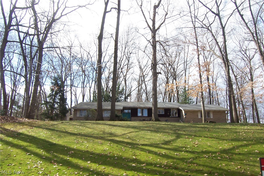 Unique 2 level one owner home! Total of 4 lots, one on either side were purchased to keep someone from building close. Wooded 2.26 acres with deer tracks everywhere! Only 4 steps separate it from being a ranch! Enter front door foyer, hall to 3 bedrooms and 2 full baths both w/double sinks. $17,000 handicap walk in tub just installed and never used! Master has bath w/tub and separate shower and walk in closet! Return to the foyer and up 4 steps to living room with beamed cathedral ceiling, family room with beamed cathedral ceiling, slider to rear deck and woodburning fireplace between the 2! Formal dining room and eat in kitchen! Down 4 steps to 2 car garage and laundry room with half bath! Large unfinished basement and concrete crawl spaces for storage! Pool table stays! All appliances and central vac! Roof 3-4 years old! Needs updating but you can't beat the private treed lot and all this home has to offer!