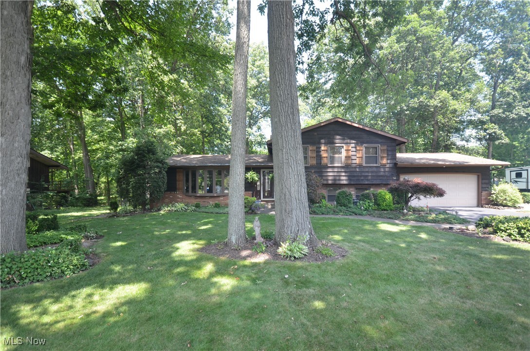Incredibly well kept & updated home located in Woodland Estates! This 4 bedroom, 3 full bath has gorgeous landscape w tons of low-maintenance plants & a beautiful 7000-8000 gallon koi pond w waterfall feature creating a relaxing oasis. The large vaulted living room features beautiful hardwood floors & open layout to the vaulted dining rm w updated chandelier & hardwood floors that continue into the remodeled kitchen w granite counters, tile backsplash, raised panel oak cabinets, pantry w roll out shelving & an eating area. The lower level family rm has a woodburning fireplace & Anderson Sliding Glass door leading to the sun rm w updated vinyl plank flooring & access to the patio plus gorgeous views of the pond & yard. A lower level bedroom has windows for daylight, closets & direct access to an updated full bathroom w granite counter, mirror, custom built vanity & tile flooring. This 4-level split includes a basement w finished rec room w wet bar plus unfinished area for storage, laundry & utilities. Upstairs Master Suite w large closet- multiple shelves/rods plus a private full bathroom w granite counter, tile floor, custom built Vanity. Additional upstairs bedrooms are a nice size & served by the hallway full bathroom - updated w granite, custom vanity & tile floor. Updates include: ‘25 Roof over Dining & Kitchen Replaced, Entire Roof treated w Roof Maxx system w 5 year transferable warranty, Hot Water Tank. ‘24 Furnace- High Efficiency w AprilAire Humidifier. ‘22 Sun Rm Vinyl Plank Flooring. ‘20 Windows Replaced (Vinyl Wood-Look Interior), Kitchen Updated. Additional updates include- all bathrooms, Ditch enclosed & Culvert Installed, Steel Door from Garage to home & programmable thermostat. Hardwood flooring is under the carpet upstairs too! Within walking distance to the Tallmadge Elementary & Middle School Campus as well as the Tallmadge Rec Center & provides easy access to the High School, Maca Pool, Multiple Parks, shopping, restaurants & highway access!