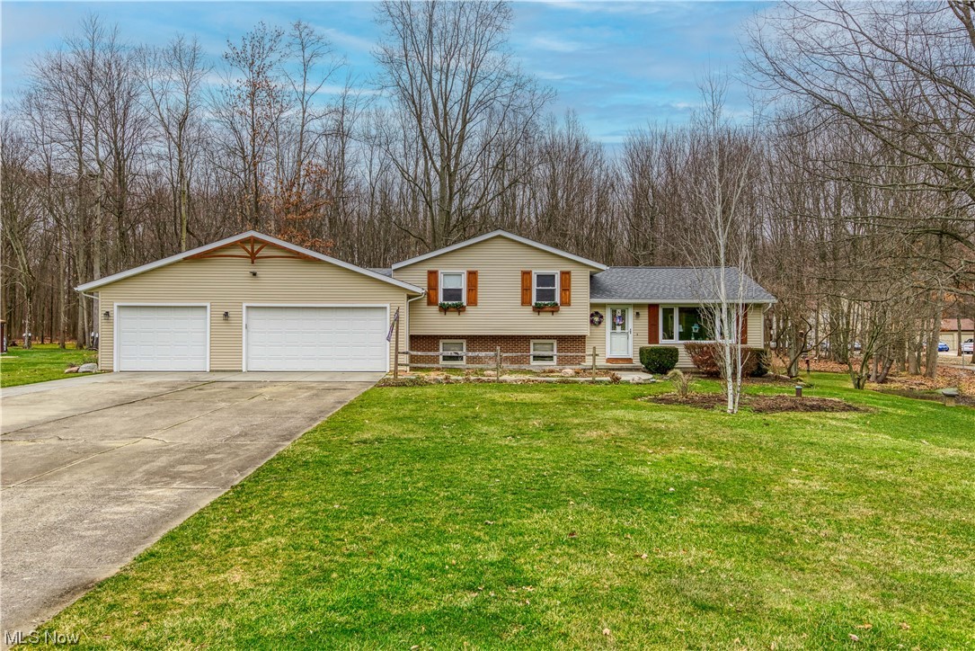 Looking for your own little piece of paradise? Look no further than this lovingly maintained split level on just over 3.5 acres. Country living, yet still close to the freeway, shopping, restaurants and Kent State University! This beautiful home offers 4 bedrooms and 2 full baths. When you pull up to the home you will notice the expansive garage addition from 2016. Heated, 3 car garage with plenty of room for storage and an oversized kennel with access to outside for your four legged friends. In the garage you also have access to the backyard and a countertop with sink area. Walking in the front door you are greeted with plenty of natural light from the large windows in the inviting living room. The kitchen and dining room are attached and provide the perfect backdrop for cooking and sharing a meal with family and friends. In the kitchen you will find plenty of counter space for prepping and ample cabinets to use. Appliances to remain for the new owners. Next, is the 4 season room with a pellet stove and access to the cedar deck with dog washing station. Upstairs you will see the 2 bedrooms that share a full bath in the hall and the Primary bedroom with attached bath. The lower level offers another living room area and the additional bedroom. The basement has a rec room, additional storage and the laundry area. The backyard has a fully fenced portion, but still another area with 3 sheds that is open. 1/5 mile walking trails on the back nearly 2 acres of the property. Bring your boots, you are welcome to walk it during your showing. Too many updates to list, contact your favorite Realtor for a showing and detailed information.