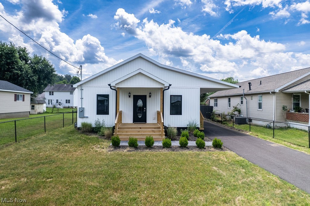 There’s something incredibly special about a home that’s been thoughtfully designed—and this one was crafted with care from the ground up. From the moment you arrive, the white vertical siding and matching mailbox create a clean, cohesive look that hints at the quality within.
Step up onto the wide front porch, and inside you’ll find an open, flowing layout that brings together the kitchen, dining area, and living space—a design that feels both inviting and functional. High ceilings, Brazilian cherry hardwood floors throughout, and custom crown molding give the home a sense of warmth and quiet elegance.
The kitchen features solid wood custom cabinetry, with several architectural light fixtures and low-profile ceiling fans adding subtle, stylish touches. The home offers true one-floor living, with both spacious bedrooms tucked toward the back for added privacy. Each bedroom includes oversized double closets, providing ample storage space.
A generously sized laundry and utility room adds convenience, while the level lot is fully fenced—just awaiting a gate for the driveway. There’s also a side porch with front and rear steps beneath a covered parking area that offers drive-through access from front to back. A custom rear porch completes the outdoor space, ideal for enjoying peaceful moments at home. Notably, the exterior walls include foam insulation for added energy efficiency, and the crawlspace—approximately four feet tall with a concrete floor—is lightly heated and cooled, offering excellent conditions for storage or access.
Every inch of this brand-new build was carefully considered, combining comfort, function, and timeless design—ready for its next chapter.