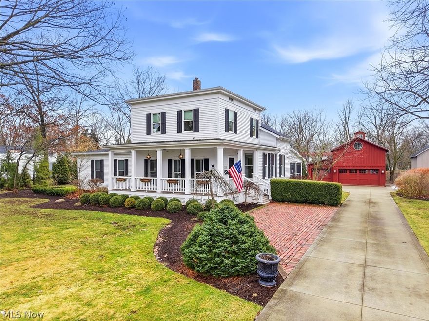 Set on an exceptional lot in Hudson’s historic village, this distinguished residence is widely regarded as one of the community’s most notable historic homes. Originally built circa 1854 by Henry Noble Day, a professor of Theology at Western Reserve College, the home carries a rich legacy deeply tied to Hudson’s early history. Today it presents a beautiful blend of period architecture and updated living spaces, soaring ceilings, charming wood floors, intricate millwork, and timeless décor throughout. The first-floor primary suite provides both comfort and privacy, complete with an adjoining den or study + an updated bath and direct access to a private exterior patio. Upstairs are three inviting bedrooms, including two connected by a shared private office + a beautifully remodeled second-floor bathroom. The home’s gracious foyer features built-in cabinetry + classic moldings. The kitchen is thoughtfully designed w white cabinetry, high-end appliances, and a center island with breakfast bar, opening seamlessly to a casual dining area with fireplace. A custom butler’s pantry + wet bar connect to a warm family room w coffered ceiling, built-ins, and expansive windows and doors that open to the patio and garden walkway. A spacious first-floor laundry + mudroom offers convenient access from the screened porch, with views of beautifully landscaped grounds. The outdoor setting is truly special, w brick patios, fire pit, privacy hedges, and a fountain. Two restored outbuildings further enhance the property. The three-car garage and barn includes a finished loft with full bath, custom Murphy bed, restored original barn flooring + HVAC. The second structure has also been fully restored and features a full bath, Murphy bed, and built-in shelving ideal for a home office, den, or guest retreat. Just steps from Hudson’s charming downtown amenities, this remarkable property represents a rare opportunity to own a truly distinctive historic home in a premier village setting.