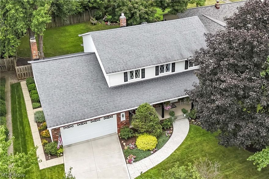 Experience a slice of heaven in this impressive Parma Hts Colonial home, situated just off the Metropark and Big Creek Parkway. Wilderness Lane lives up to its name, offering privacy and seclusion thanks to the mature trees and wooded area across from the home. Coveted front porch invites you to enjoy the scenic view and lush landscaping before stepping inside to discover a harmonious blend of traditional features and modern updates. Center staircase is flanked by a home office and front living room. The formal dining room, enhanced by decorative wood trim and an elegant chandelier, is a sophisticated space for gatherings. Beautifully updated kitchen with granite counters, white cabinetry, timeless ceramic backsplash, and double bowl stainless sink with a newer window overlooking the deck and yard. Luxury vinyl plank floors, updated fixtures and stainless appliances complete the modern look. The kitchen flows seamlessly into the stunning family room, featuring a gas fireplace, built-in bookshelves, and an enormous bay window, the perfect spot to sit and enjoy the gorgeous yard, accessible from the family room entry or kitchen slider. A first floor laundry and half bath complete the main floor. Upstairs, you will find four bedrooms and two full baths. A beautiful primary suite has a massive walk-in closet and tastefully updated en-suite featuring dual sink vanity, tub/shower combination, and linen closet. The full guest bath is also nicely updated, along with three additional charming bedrooms. Finished lower level offers endless possibilities and currently serves as a TV area, children's playroom, and workout area. A full bath and storage closets round out this versatile basement. Outside, you'll love the fully fenced lot, stunning flower beds, deck and covered patio for intimate gatherings. Search no more, the dream forever home you have been hunting for can finally be yours.