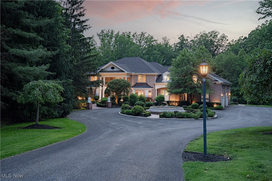 Privately nestled in Gates Mills, this breathtaking estate is a true showcase of elegance, craftsmanship, and refined living. A circular drive leads to a stately columned entrance with custom double doors, opening into a dramatic foyer with a dazzling chandelier and intricate millwork. The curved staircase features a custom Finelli Iron rail, and striking murals throughout the home were created by renowned artist Bob Dasher. The grand living room impresses with floor-to-ceiling windows, a statement fireplace, and a full wet bar—perfect for intimate relaxation. Just off the foyer, French doors open to a richly appointed office with coffered ceilings and custom-built-ins, while the formal dining room showcases classic wainscoting and elegant moldings. The gourmet kitchen impresses with a large island, granite counters, high-end appliances, custom cabinets, walk-in pantry, and a bright eat-in area open to the great room. The first-floor primary suite offers a peaceful retreat with a fireplace, dual walk-in closets, and a spa-like bath featuring a deep soaking tub, oversized shower, and double vanity. Upstairs, four spacious bedrooms each have private ensuite baths, and a large bonus room above the garage adds versatile living space. The finished lower level offers a resort-style experience, complete with a sixth bedroom, a stylish full bath, and an additional bath, featuring a steam room and sauna. You'll also find a spacious rec room with a wet bar and dance area, a billiards room that opens to an Old World-style wine cellar, a private theatre, and a full home gym. Outside, the grounds are spectacular—professionally landscaped with architectural design and meticulously crafted hardscaping. Multiple stone patios, a deck, an inground stone spa, a gas-powered outdoor fireplace, and a separate gas firepit create a five-star outdoor living experience year-round. Timeless architecture, exceptional amenities, and a premier Gates Mills location—Luxury living at its finest!
