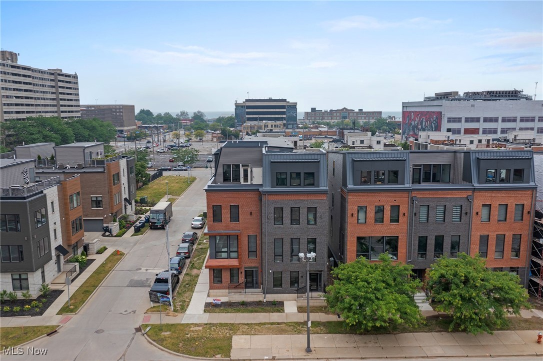 Luxury contemporary townhouse in Downtown Cleveland! The perfect blend of downtown living and a spacious house. There's an attached, heated 2-car garage with EV charger, and a big, private roof deck. Four floors of very well-designed living space with 3 bedrooms, each with their own ensuite bath, and powder rooms on both the main (2nd floor) level and in the 4th floor great room set it very much apart from comparable downtown apartments. Beautiful finishes complete the picture, with a combination of hardwood and luxury vinyl/wood flooring throughout. The 1st floor has a generously sized foyer, and a bedroom with full bath that makes a perfect office or workout room. In the main living space the kitchen has a stunning, oversized waterfall-style island in white quartzite, with plenty of counter and cabinet space and upgraded stainless steel appliances. The living room has a big wall fireplace and large windows. The master bedroom has a pair of walk-in closets, and an elegant bath with a large shower and separate toilet. The other bedroom on the upper floor has its own bath and another, large walk-in closet. All the rooms have plenty of light, with large windows and high style, charcoal colored power blinds. The 4th floor has a gorgeous skyline view of Playhouse Square, and a large, very private roof deck. There's a wet-bar and a 2nd half-bath that make it an ideal entertaining or everyday living space. A spacious, like-new townhome. All of downtown is only a short walk from home. Or enjoy incredibly easy access to everything in Greater Cleveland by car: Route 2, I-90, I-77 and I-71 are all only a few minutes away, and it's 15 a minute drive to the Airport. Then have the best downtown living perk of all. Avoid the downtown traffic congestion with that same, easy freeway access, and when you get home, drive right into your own heated garage, and walk right into the house.