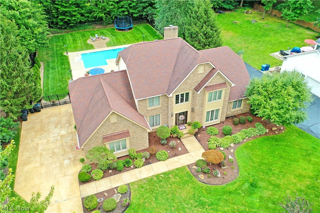 Breathtaking from every angle, this magnificent Howland home is filled with custom touches, lavish updates and high style throughout! The prominent two-story home quickly stands out with its striking brick work that covers the front of the residence. Carefully manicured landscaping wraps around to find a must-see, fenced-in backyard. Here you can revel in your own personal getaway to include a sparkling saltwater inground pool and bold red, tiered patio area set just off the finished sunroom. A decorative entry door opens to showcase a towering grand foyer with a wrapping staircase rising to the second-floor guest bedrooms. Tiled flooring spills out towards the great room while an inviting parlor/ family room site opposite of the lavish formal dining room. The grandiose living room steps down to showcase hardwood flooring and its impressive stone accent wall with inset fireplace and tall stacked windows. Casual dining joins an elaborate kitchen filled with warm woodwork, stainless appliances and polished stone countertops. Natural light filters in from the window lined sunroom just steps away. A full first floor bath and laundry services preside further down the hall. Finishing the first floor, an expansive master suite includes an oversized bedroom, walk-in closet and decadent full bath with shower and sun washed soaking tub. Upstairs, three additional bedrooms offer spacious living quarters as they join an additional full bath. Meanwhile, a finished basement with plenty of rec space, storage and additional full bath is poised to entertain.