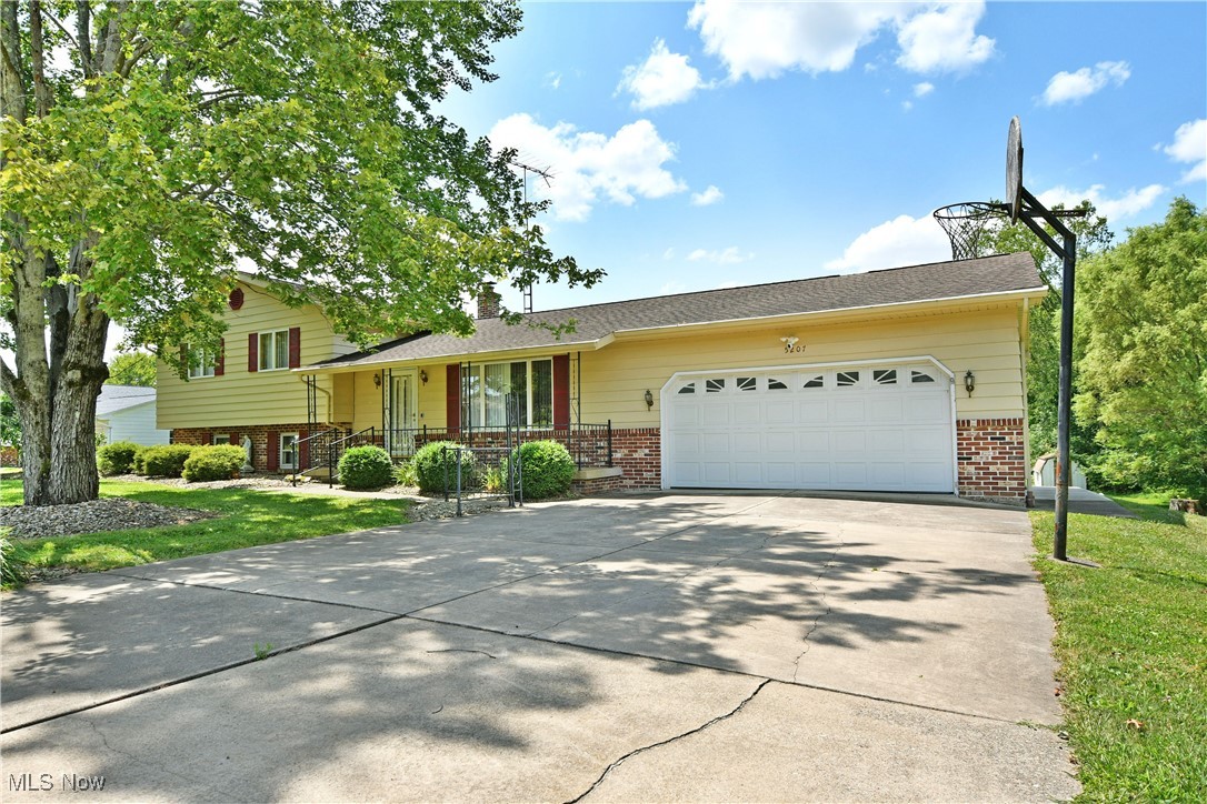 Have you been dreaming of the perfect semi-rural backyard, with over 4 acres of space to run and play, all set beside a private, natural tree line? Don’t miss this stunning Champion Township property, where you can enjoy sun-soaked views all year long! This charming four-bedroom split-level home offers four levels of finished living space, perfect for whatever you need. The brightly colored home is hard to miss, with its beautiful brick accents and the shade of a tall tree framing its front. A cement driveway leads to a freshly painted, two-car attached garage. Inside, a gracious tiled foyer opens into the carpeted living room, framed by elegant stone and spindle partitions. The kitchen continues the flow with custom wooden cabinetry and stainless steel appliances, all set within a spacious galley layout. Relax in the finished sunroom, a versatile space ideal for summertime dining or cozy evenings year-round. Upstairs, decorative lighting brightens the landing, while a full bath features a tiled tub and shower surround. Three generous bedrooms branch off the hall, each with ample closet space and warm wood trim. The lower level offers a wood-paneled family room with a stone fireplace, perfect for cozy gatherings. A second full bath accompanies a versatile fourth bedroom/bonus room. The finished basement expands your living options with a rec area, full kitchenette, laundry, and hidden utilities. Additionally, you'll find extra storage before the walk-out basement that leads to the garage. Plus a one-year home warranty!