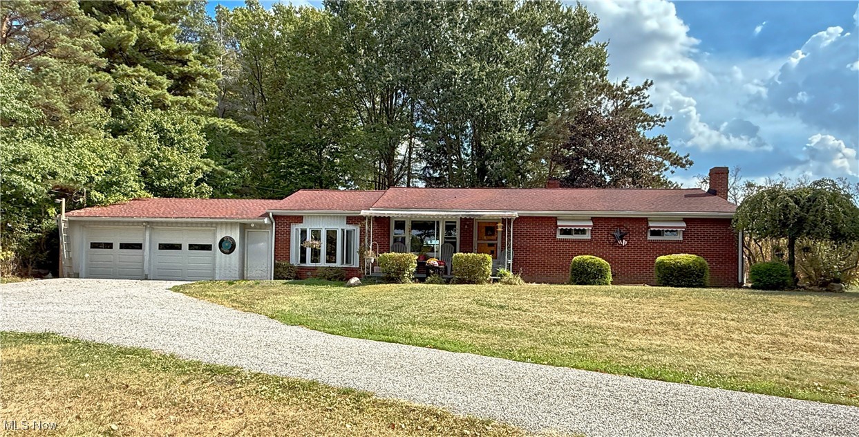 Looking for a little bit of country? This 3-4 bedroom, 2.5 bath, brick ranch in West Branch Schools is a rural gem, set on 1 acre, with a welcoming covered porch, a convenient horseshoe driveway and vinyl windows that were updated just a year ago.
Step inside and discover a layout full of versatility. The original living room, with hardwood floors, is now being utilized as a spacious dining room, perfect for gathering around the table. The breezeway has been converted into a large living room with its own electric baseboard heat, LVT flooring, a bay window, a half bath, and sliding glass doors that open into the 3 season/sunroom, where you can relax and enjoy the views of your own slice of the countryside.
The kitchen is generously sized with an abundance of cabinetry and counter space, and the stove, refrigerator, and dishwasher all stay. Down the hall, you’ll find three bedrooms—one currently used as a closet, another for storage—and a full bath with a tub/shower combo. The finished basement is a true bonus, offering a rec room/family room with tongue-and-groove hardwood walls and a propane fireplace (the propane tank can stay). There’s also an optional 4th bedroom/office with 2 double closets and a spacious laundry area that houses another full bath (the step-in shower is being used for storage) and a hallway of storage closets. This home offers the space you need, the charm you’ll love, and the country setting you’ve been looking for. Come take a look, you might just picture yourself calling it home.